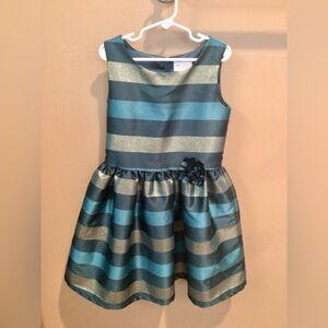 Formal girls dress. Shiny striped fancy dress with flower at the waist.